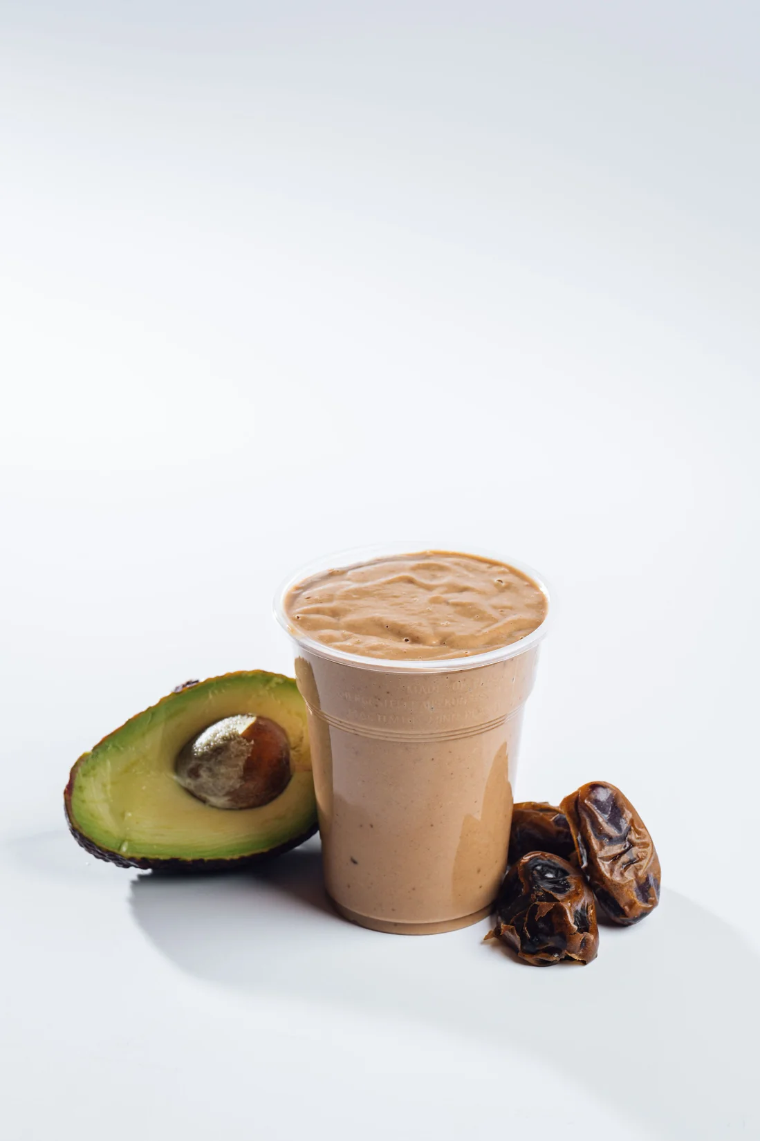 A TINK smoothie with avocado and dates beside the cup